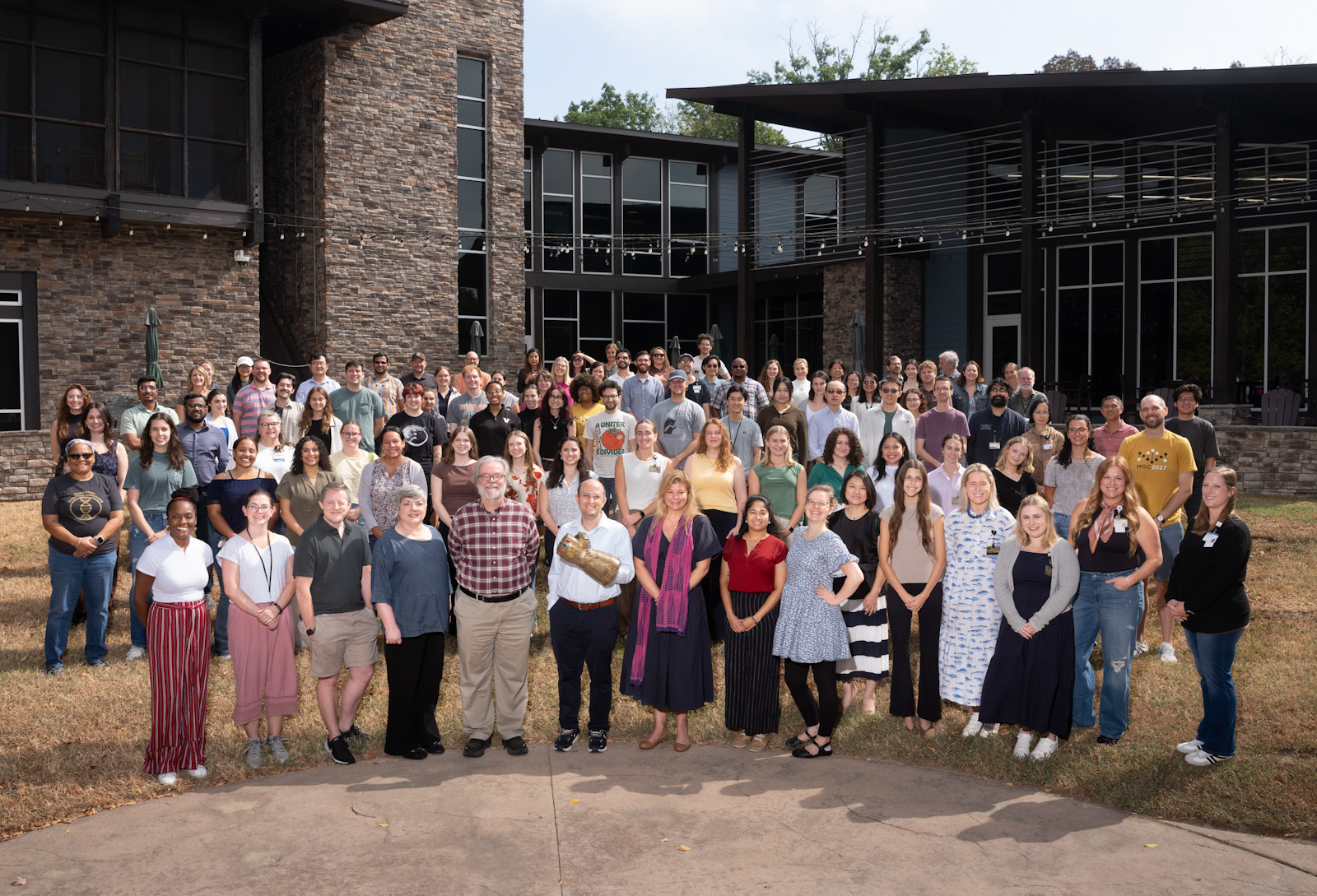 A large group of scientific researchers poses outside a retreat center.