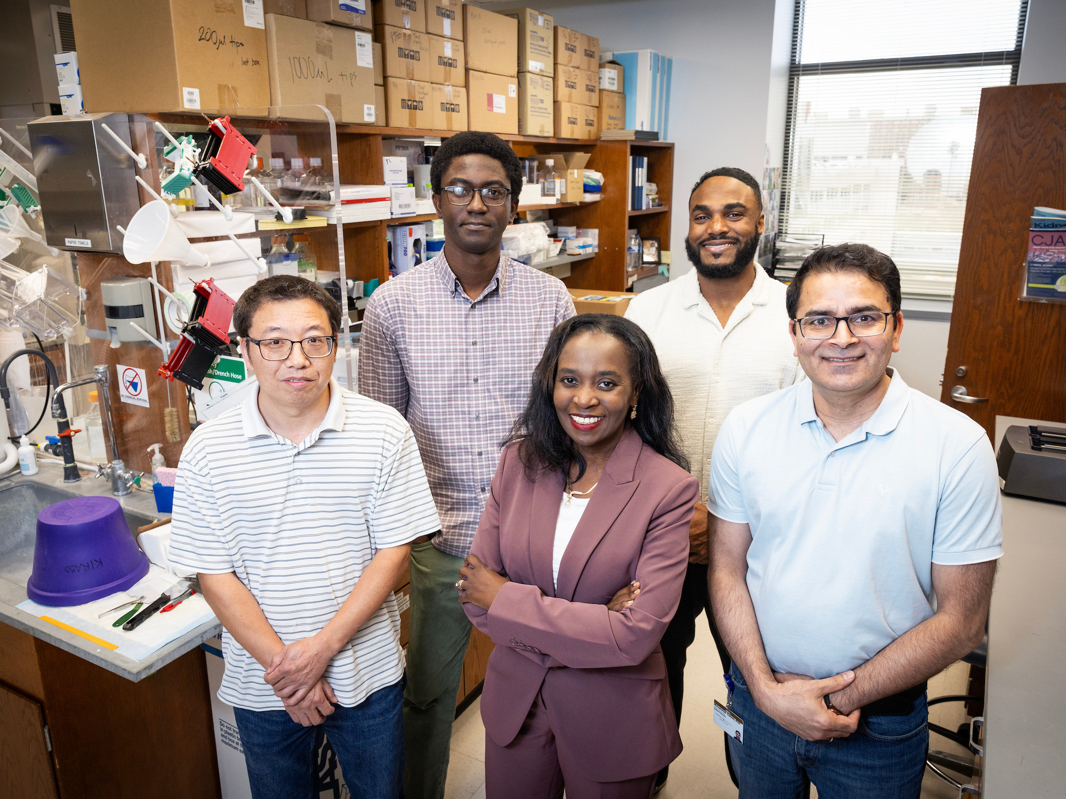 Dr. Annet Kirabo and four male members of her research team in their lab.