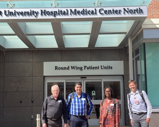 Four Aurum and VUMC colleagues pose outside the hospital's round wing.