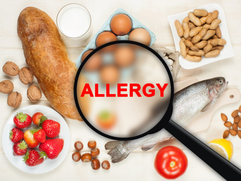 A collage of common food allergies including bread, fish, eggs, nuts, and strawberries