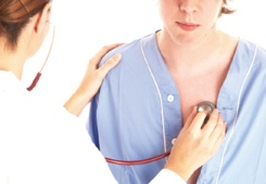 A female doctor checks the heartbeat of a female patient with a stethescope. 