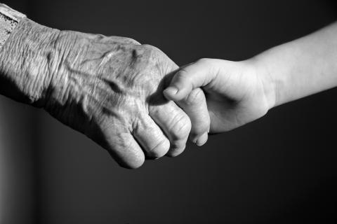 elderly hand holding child's hand