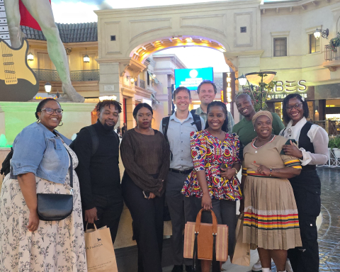 Dr. Yuri van der Heijden, and Charles Rhea pose with South African colleagues in a shopping center.